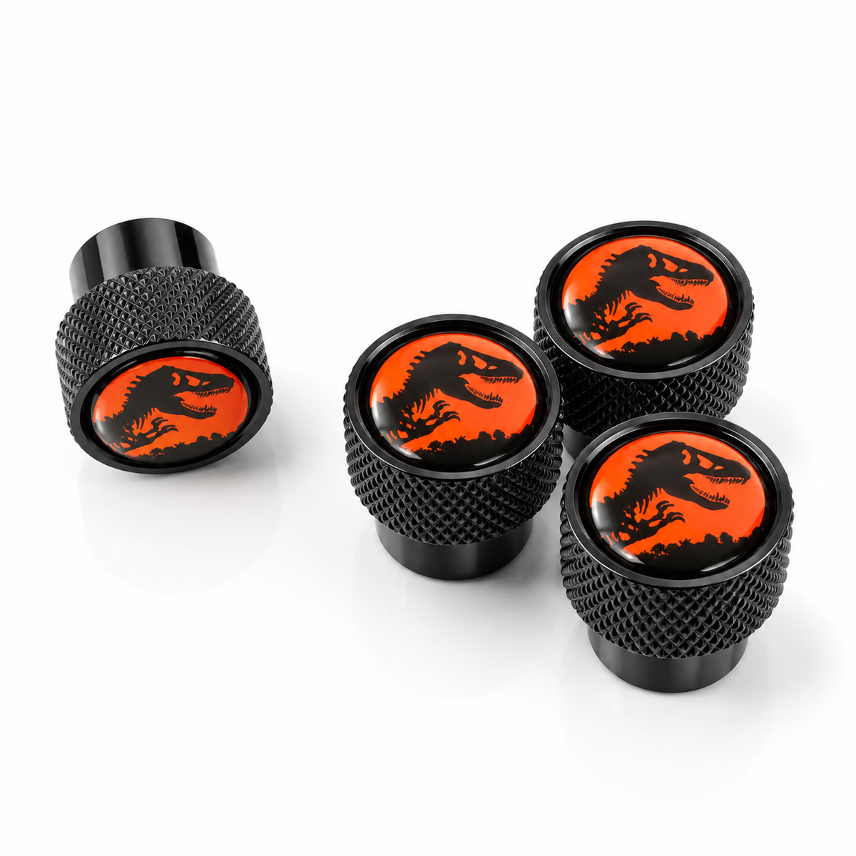 Set of four black oversized valve caps with orange Jurassic dinosaur artwork